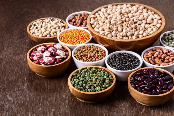 Various assortment set of indian legumes in bowls on wooden background with copyspace. Vegetable proteins. Protein products for vegans. Healthy eating concept.