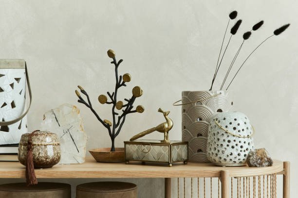 Beautiful living room interior design with candlestick, vases, mineral and personal accessories on the wooden console. Copy space. Template.