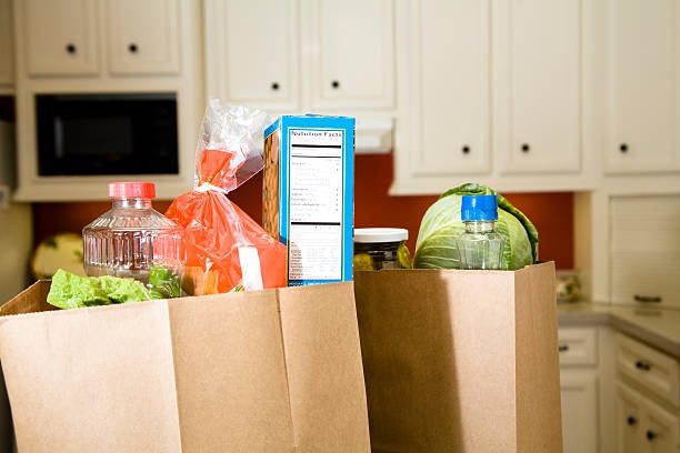 Full grocery bags sitting on the kitchen counter.