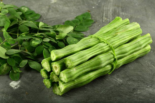 Tropical vegetable- moringa, ladies finger slices on a rustic background.